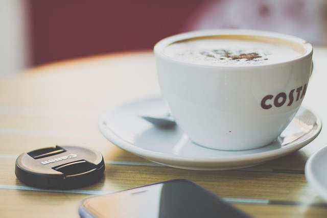 テーブルの上に、コーヒーとスマートフォン。